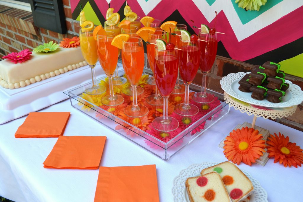 Create and host a Graduation Party with neon themed Gerber daisies, easy pick up foods and a brightly decorated table. This Graduation Party reception features a cake that is spot on with baked themed in color, cake balls inside the cake, triple lemonade and candy graduation caps.