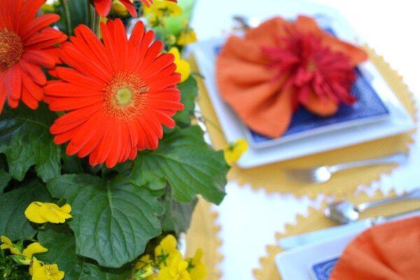 Gerber Red Daisies & Yellow Viola Centerpiece with cobalt placesetting lizbushong.com