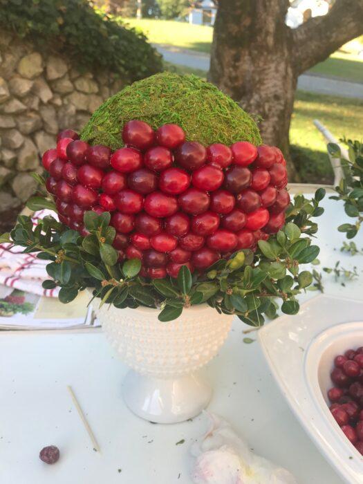 How to make a cranberry boxwood topiary centerpiece adding the berries to foam ball lizbushong.com